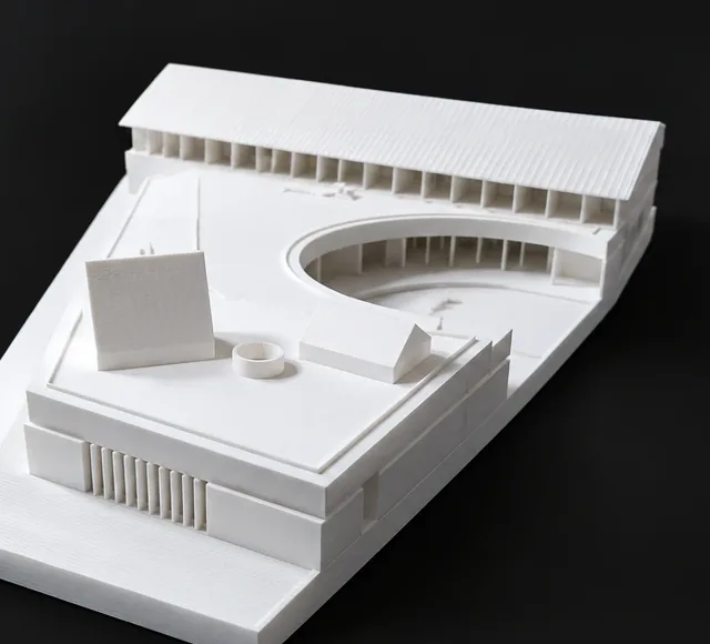 Maquette blanche d'un ensemble de bâtiments imprimée en 3D: toiture à sheds, cour en arc de cercle et volumes posés sur le socle